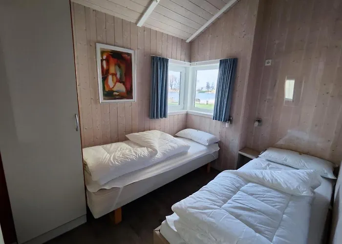 6 Personen Ferienhaus in 1. Reihe zum See mit Kanu und herrlichem Seeblick, Sauna, Whirlpool, Kaminofen, Klimaanlage und E-Tankstelle am Haus in Otterndorf